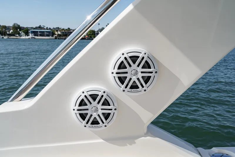 Slide: The Image of Two white speakers are mounted on the side of a boat, with water in the background. - 37
