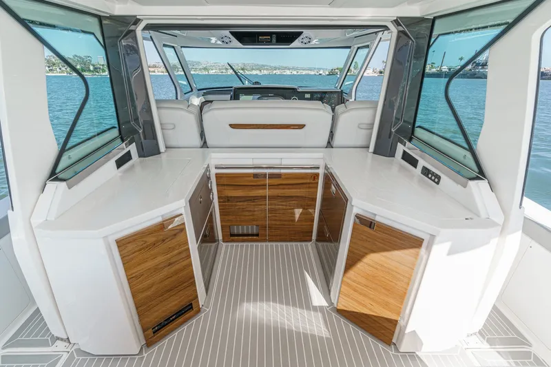 Slide: The Image of Interior of a 2023 Tiara Yachts 48 LS with sleek wooden cabinetry and large windows. - 25