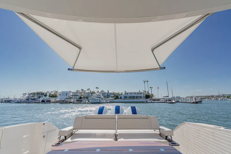 Slide: The Image of A luxury boat with a sunshade, overlooking a calm marina and modern buildings in the background. - 20
