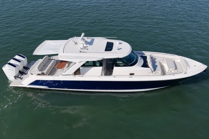Slide: The Image of The 2023 Tiara Yachts 48 LS is a sleek motorboat with three outboard engines and a luxurious deck. - 5