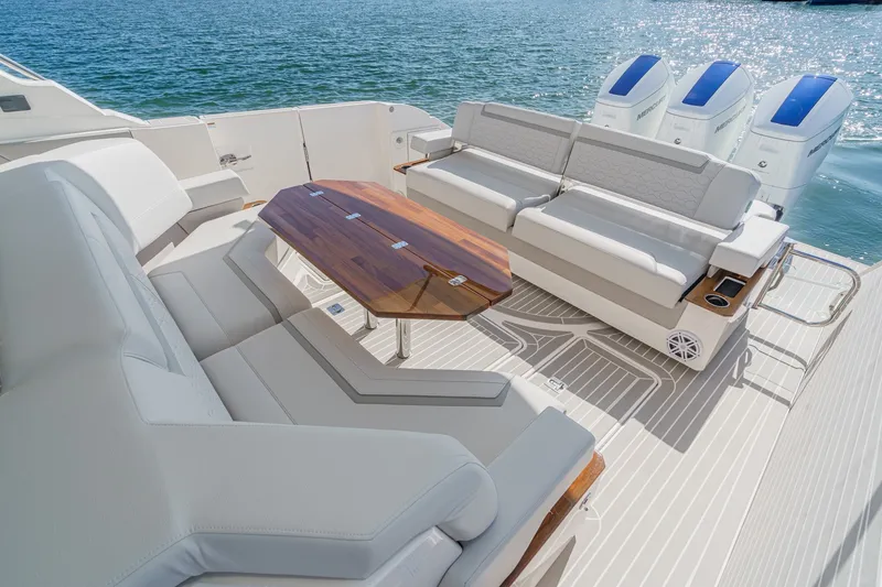 Slide: The Image of The image shows the luxurious aft deck of a 2023 Tiara Yachts 48 LS with elegant seating and a wooden table. - 22