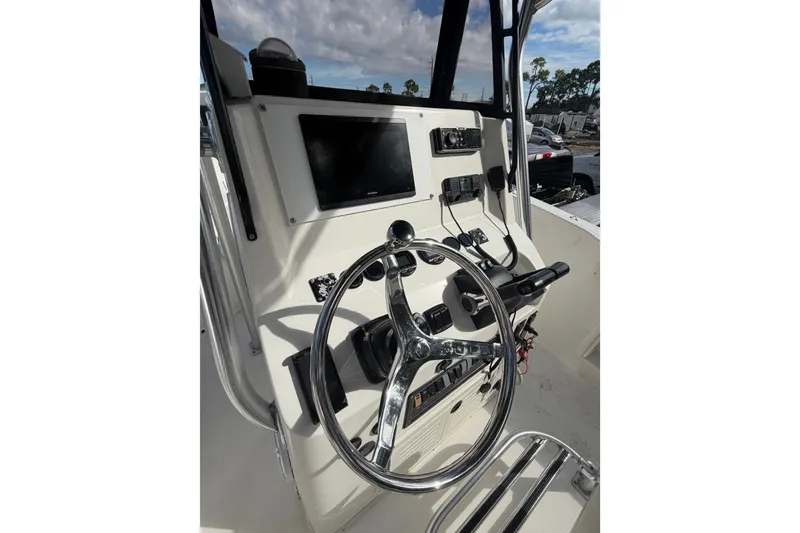 Slide: The Image of Center console of a 2000 Mako 232 boat with steering wheel and controls. - 10