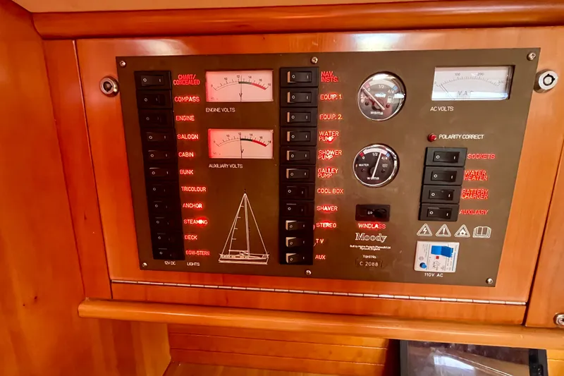 Slide: The Image of Electrical control panel on a 2000 Moody 42 yacht, featuring various switches and gauges. - 13