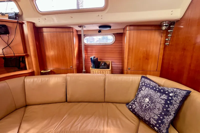 Slide: The Image of Cozy interior of a 2000 Moody 42 yacht with wooden cabinetry and a cushioned seating area. - 7