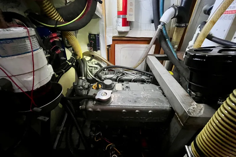Slide: The Image of Engine room of a 2000 Moody 42 yacht, featuring complex machinery and hoses. - 42