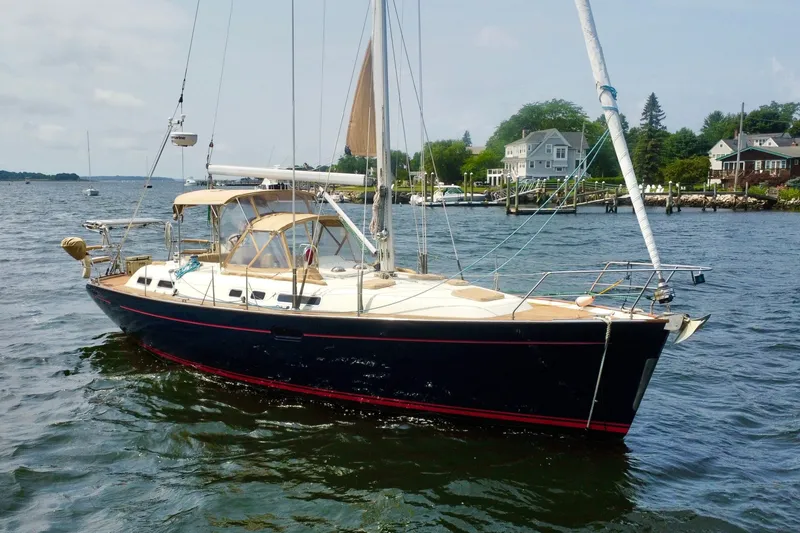 Slide: The Image of Sailboat Moody 42 (2000) on water near coastal homes, clear sky. - 2