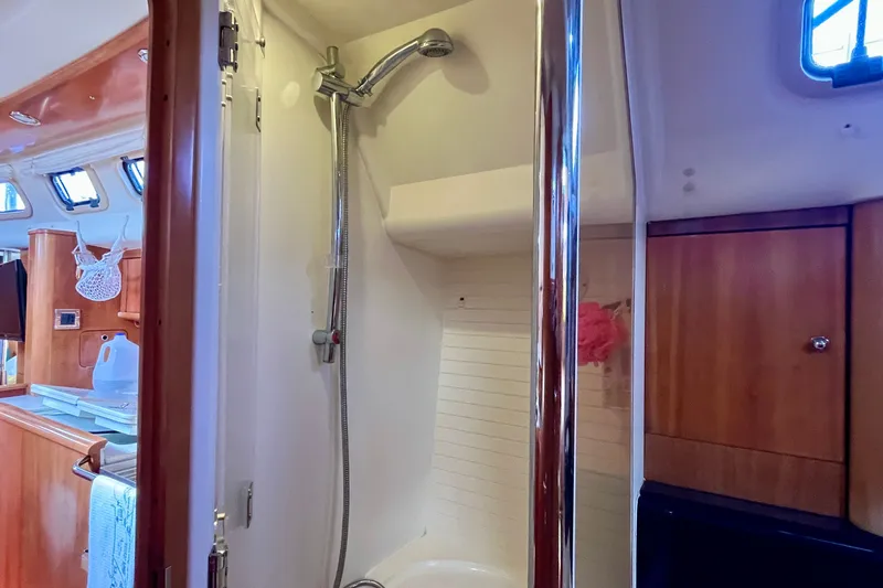Slide: The Image of Shower area inside a 2000 Moody 42 yacht, featuring wooden cabinetry and modern fixtures. - 21