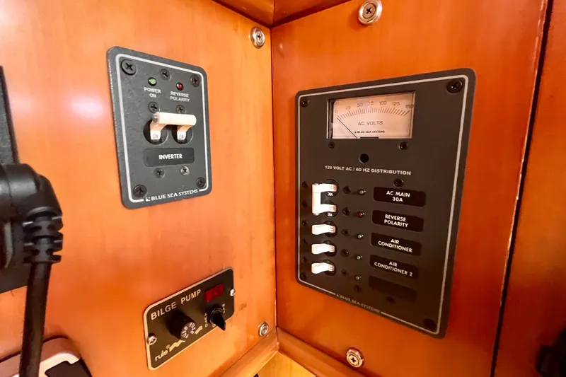 Slide: The Image of Electrical control panel on a 2000 Moody 42 yacht, featuring inverter and bilge pump switches. - 37