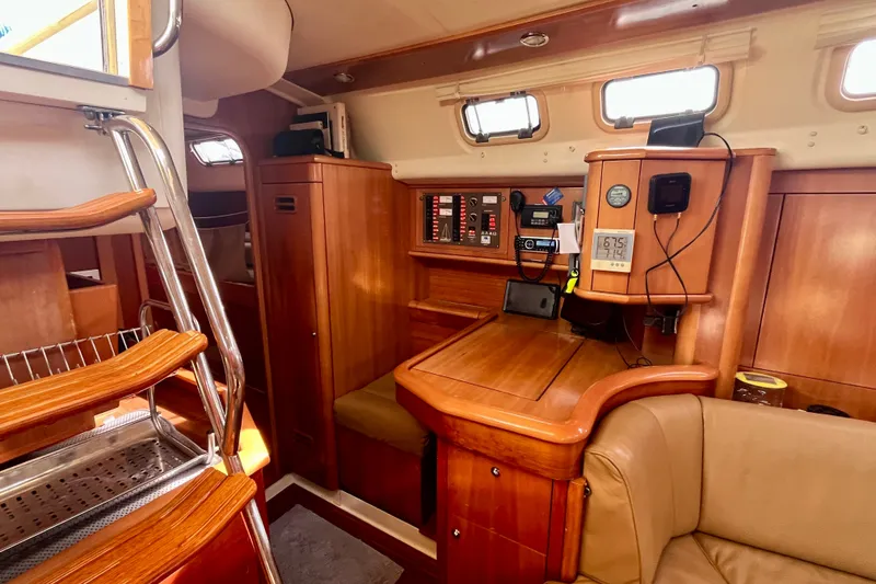 Slide: The Image of Interior of a 2000 Moody 42 sailboat, featuring wooden cabinetry and navigation equipment. - 12