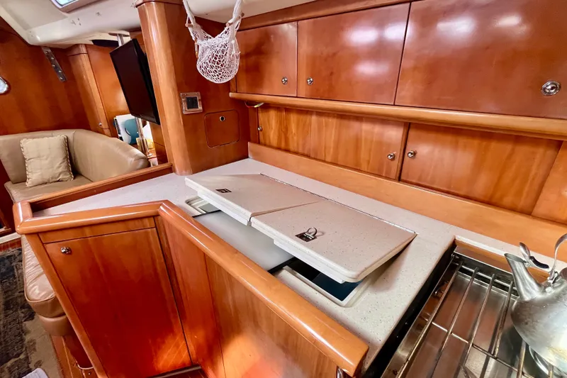 Slide: The Image of Luxurious Moody 42 yacht interior, featuring elegant wood cabinetry and modern kitchen amenities. - 26