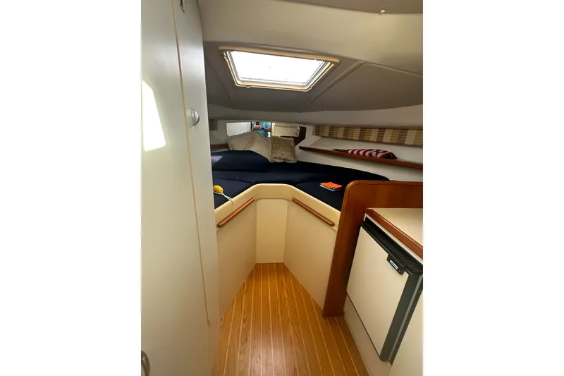 Slide: The Image of 2005 Tiara Yachts 2900 Coronet cabin interior with bed, skylight, and compact kitchenette. - 20