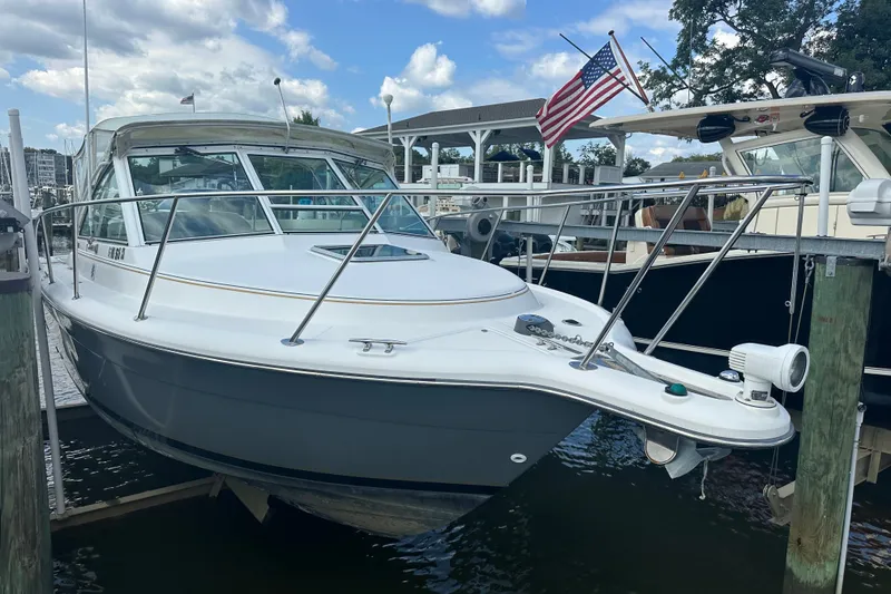 Slide: The Image of 2005 Tiara Yachts 2900 Coronet docked, featuring sleek design and American flag. - 4