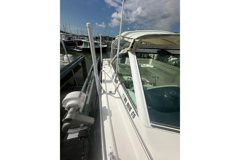 Slide: The Image of 2005 Tiara Yachts 2900 Coronet docked at marina under a partly cloudy sky. - 8