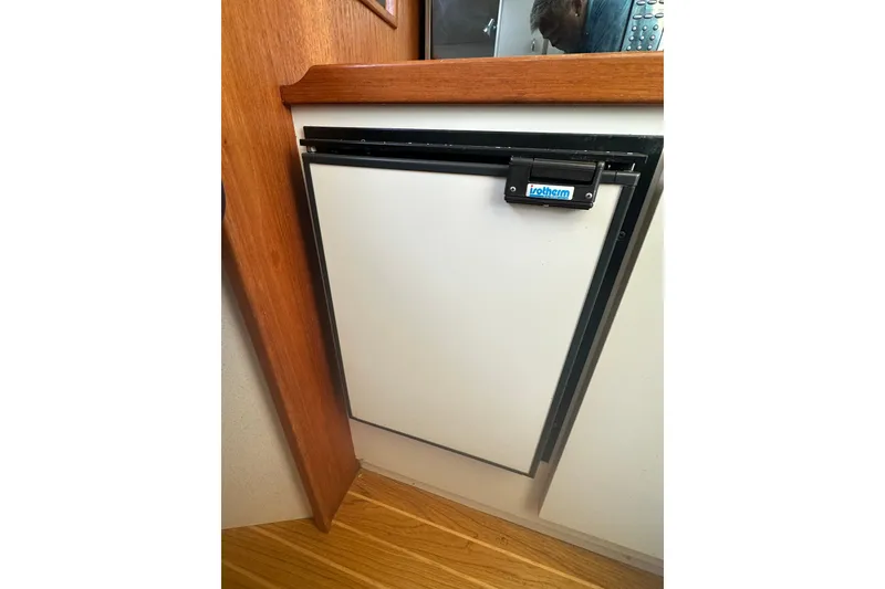 Slide: The Image of Compact refrigerator in 2005 Tiara Yachts 2900 Coronet, featuring wooden cabinetry. - 18