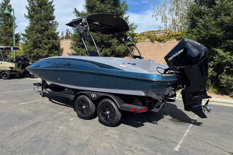 Slide: The Image of 2027 Tahoe 2150 boat with Mercury engine on trailer in parking lot. - 1