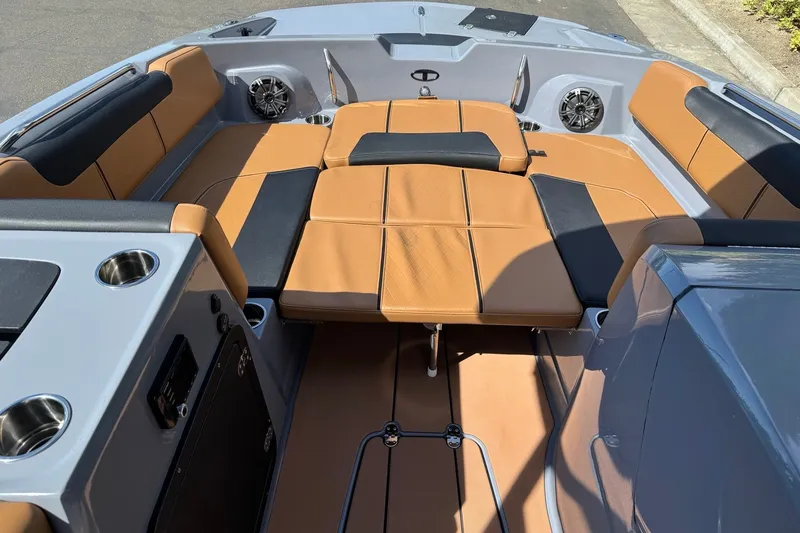 Slide: The Image of 2027 Tahoe 2150 boat interior with tan and black seating, cup holders, and speakers. - 10