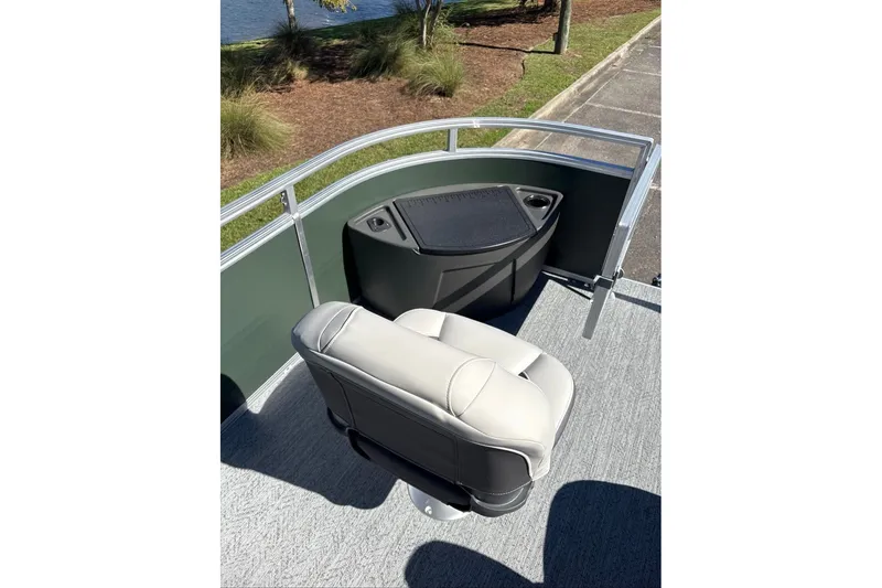 Slide: The Image of 2027 Sun Tracker Fishin' Barge 22 DLX boat seat and storage area, outdoor setting. - 14