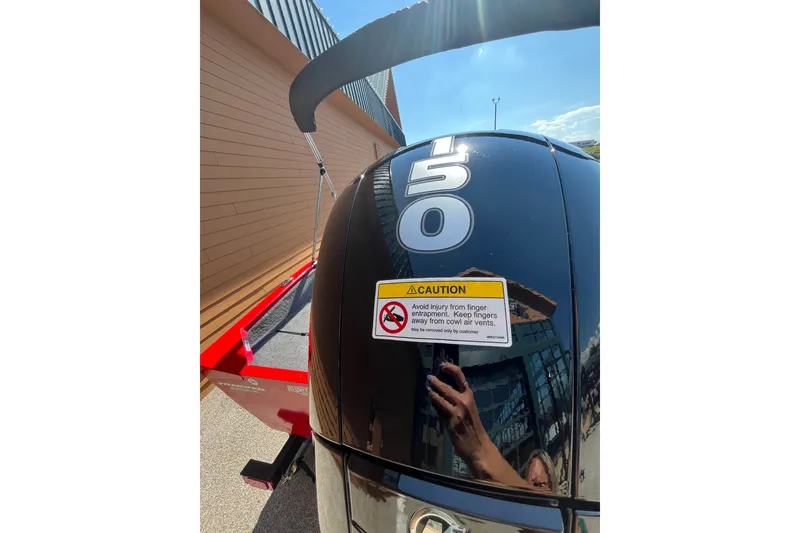Slide: The Image of Outboard motor on 2027 Tracker Pro Guide V-175 Combo with caution label and reflection. - 50