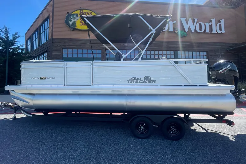 The Image of 2027 Sun Tracker Party Barge 22 RF DLX pontoon boat outside Bass Pro Shops. - 0