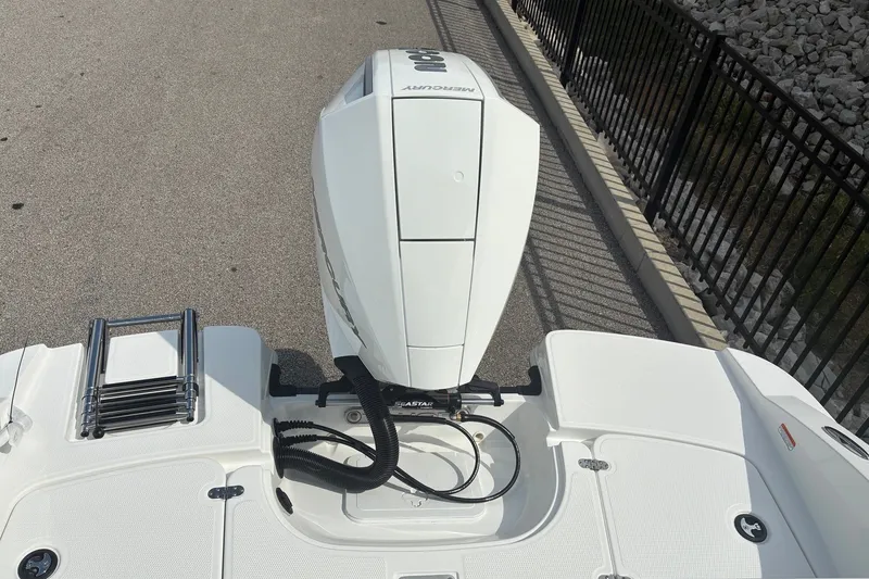 Slide: The Image of 2027 Tahoe 2150 CC boat with Mercury engine, docked near a metal railing. - 12
