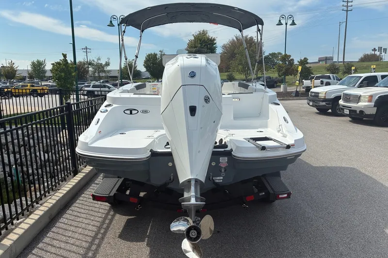 Slide: The Image of 2027 Tahoe 2150 CC boat with outboard motor, parked on a trailer in a lot. - 1