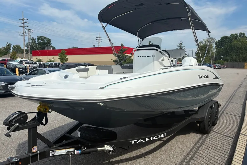 Slide: The Image of 2027 Tahoe 2150 CC boat on trailer with canopy, parked in a lot. - 5