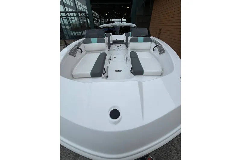 Slide: The Image of 2027 Tahoe T21 boat interior with gray and white seating, docked indoors. - 2