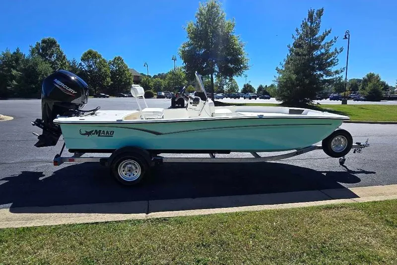 Slide: The Image of 2027 Mako Pro Skiff 17 CC boat on trailer, parked outdoors on sunny day. - 8