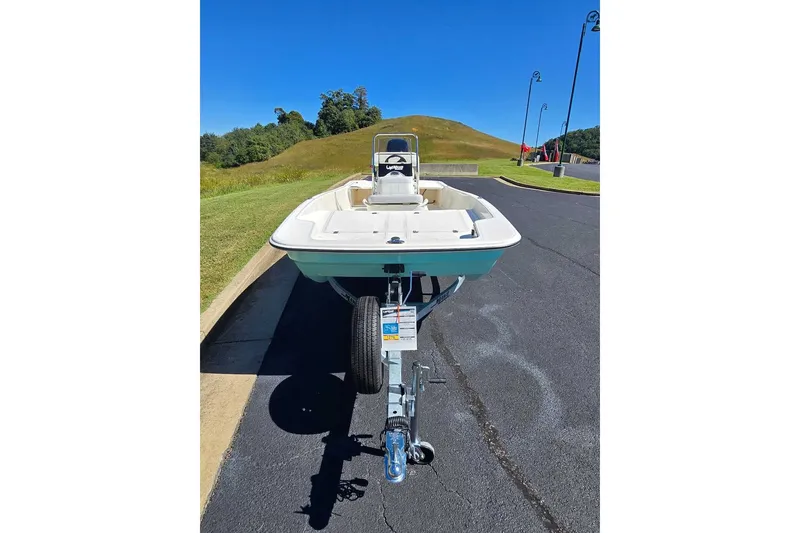 Slide: The Image of 2027 Mako Pro Skiff 17 CC boat on trailer, parked on a sunny road. - 5
