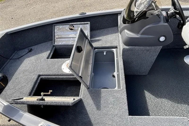 Slide: The Image of 2027 Tracker Super Guide V-16 SC boat interior with open storage compartments and steering console. - 17
