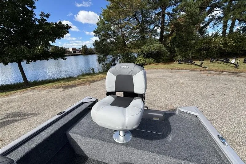 Slide: The Image of 2027 Tracker Super Guide V-16 SC boat seat by a scenic lake. - 24