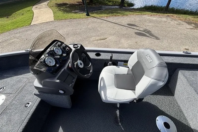 Slide: The Image of 2027 Tracker Super Guide V-16 SC boat interior with steering console and cushioned seat. - 21