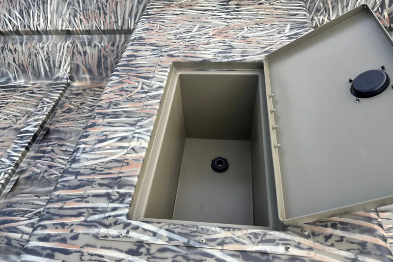 Slide: The Image of 2027 Tracker Grizzly 15 Jon boat with open storage compartment, camo pattern design. - 13