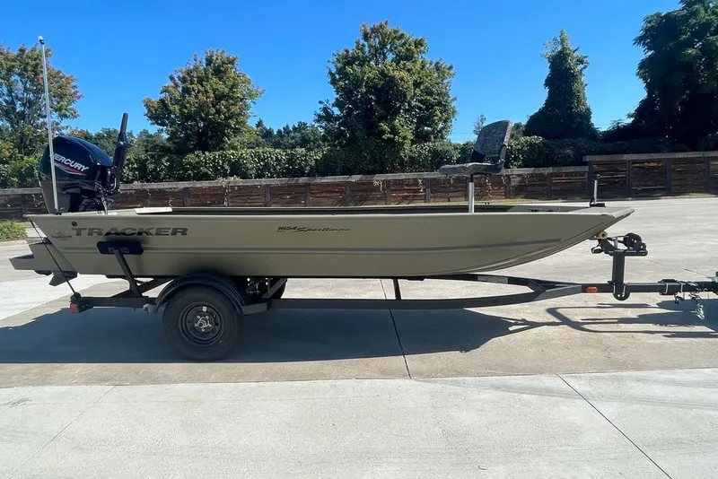 The Image of 2027 Tracker Grizzly 1654 T Sportsman boat on trailer, outdoors in sunny setting. - 0
