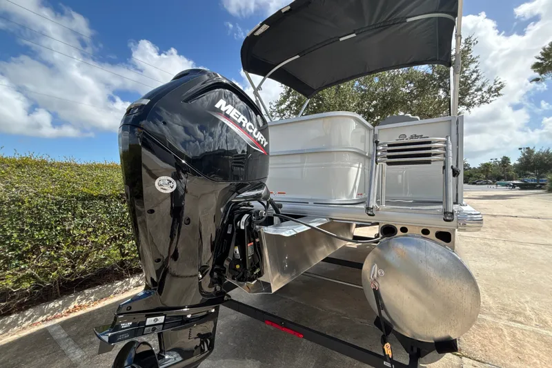 Slide: The Image of 2027 Sun Tracker Party Barge 18 DLX with Mercury outboard motor, parked outdoors. - 108