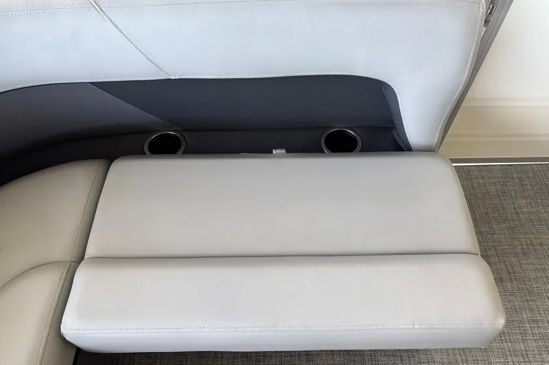 Slide: The Image of Sun Tracker Party Barge 18 DLX 2027 interior seating with cup holders, gray upholstery. - 18
