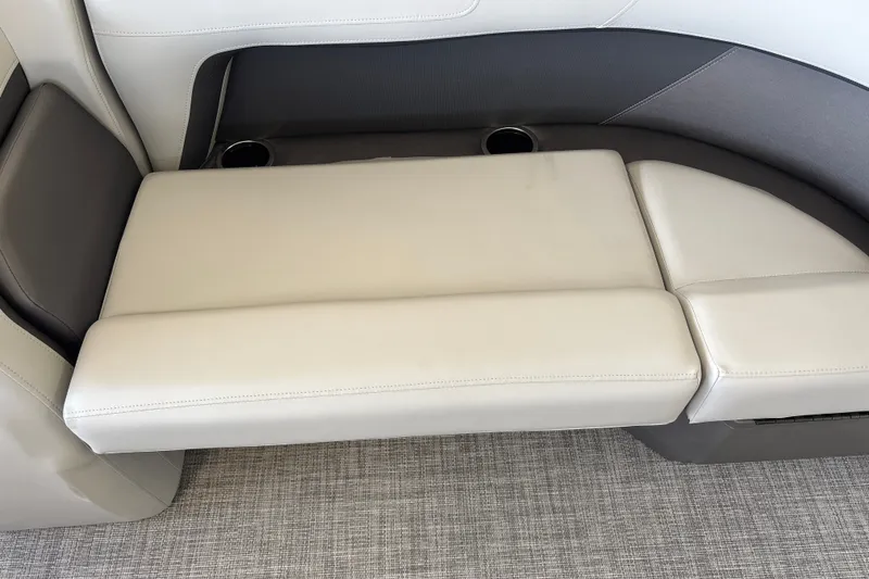 Slide: The Image of 2027 Sun Tracker Party Barge 18 DLX boat seating with cup holders and beige upholstery. - 19