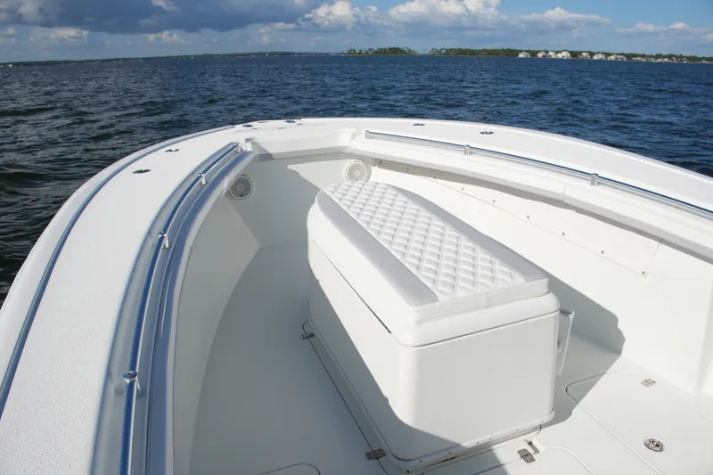 Slide: The Image of 2014 Yellowfin 32 Offshore boat interior with cushioned seating on open water. - 44