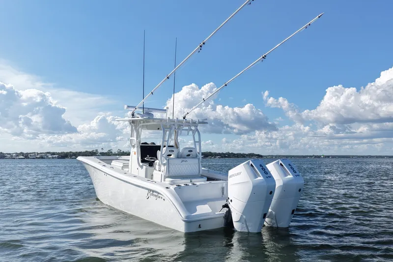 Slide: The Image of 2014 Yellowfin 32 Offshore boat with dual Mercury engines on calm water. - 23