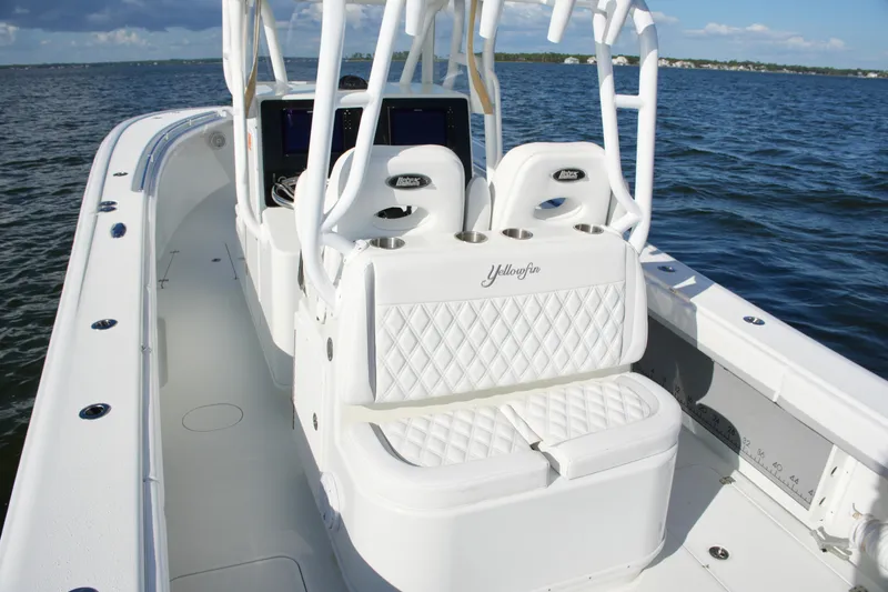 Slide: The Image of 2014 Yellowfin 32 Offshore boat interior with white seating and ocean backdrop. - 30