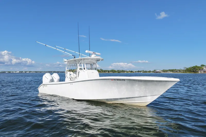 Slide: The Image of 2014 Yellowfin 32 Offshore boat on calm water under clear blue sky. - 13