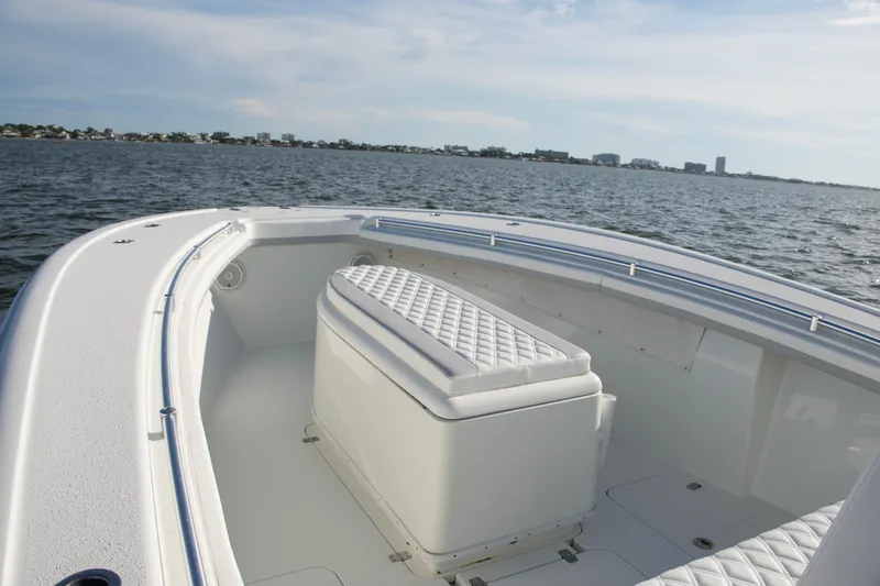 Slide: The Image of 2014 Yellowfin 32 Offshore boat interior with cushioned seating on open water. - 45
