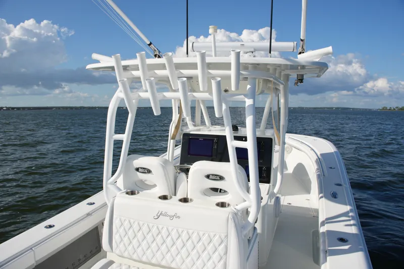 Slide: The Image of 2014 Yellowfin 32 Offshore boat on open water, featuring white seating and fishing rod holders. - 32