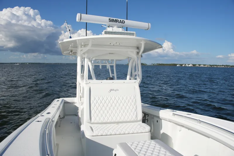 Slide: The Image of 2014 Yellowfin 32 Offshore boat on open water under clear blue sky. - 47