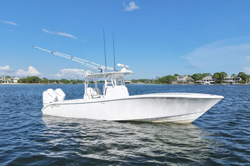Slide: The Image of 2014 Yellowfin 32 Offshore boat on calm water under clear blue sky. - 14
