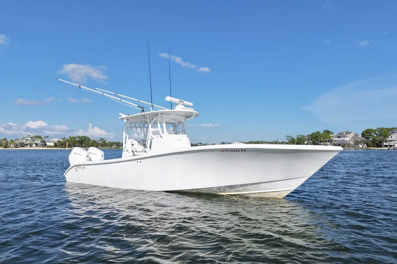 Slide: The Image of 2014 Yellowfin 32 Offshore boat on calm water under clear blue sky. - 20