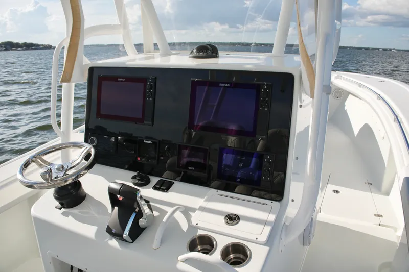 Slide: The Image of 2014 Yellowfin 32 Offshore boat dashboard with advanced navigation systems on open water. - 37