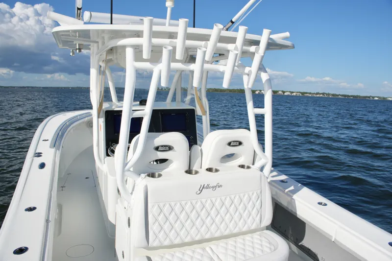 Slide: The Image of 2014 Yellowfin 32 Offshore boat with white seating, rod holders, and ocean backdrop. - 31