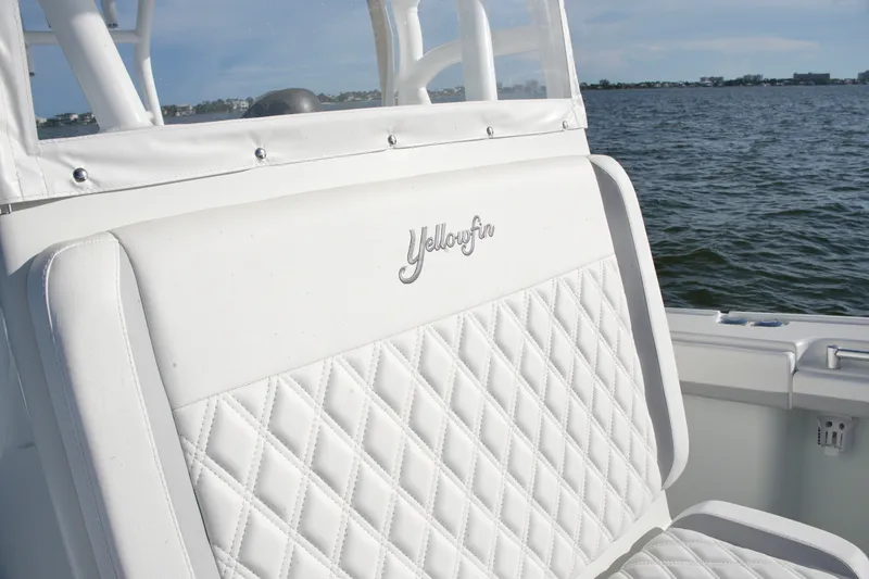 Slide: The Image of 2014 Yellowfin 32 Offshore boat seat with diamond stitching, overlooking calm waters. - 57