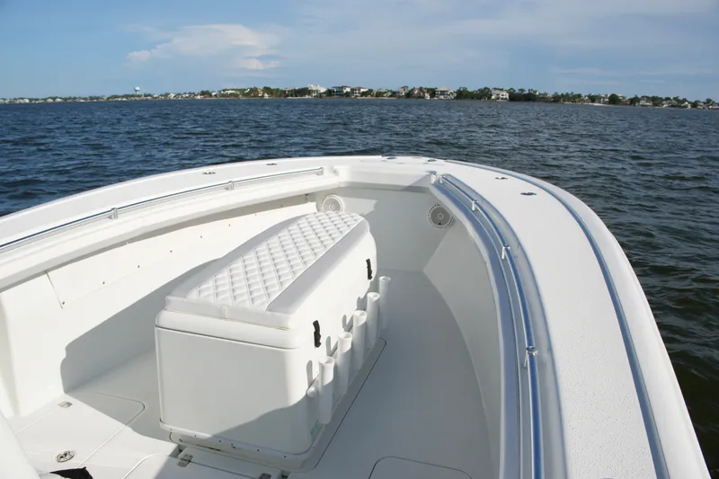 Slide: The Image of 2014 Yellowfin 32 Offshore boat on calm water, featuring spacious seating and sleek design. - 46